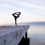 A woman doing yoga on a dock